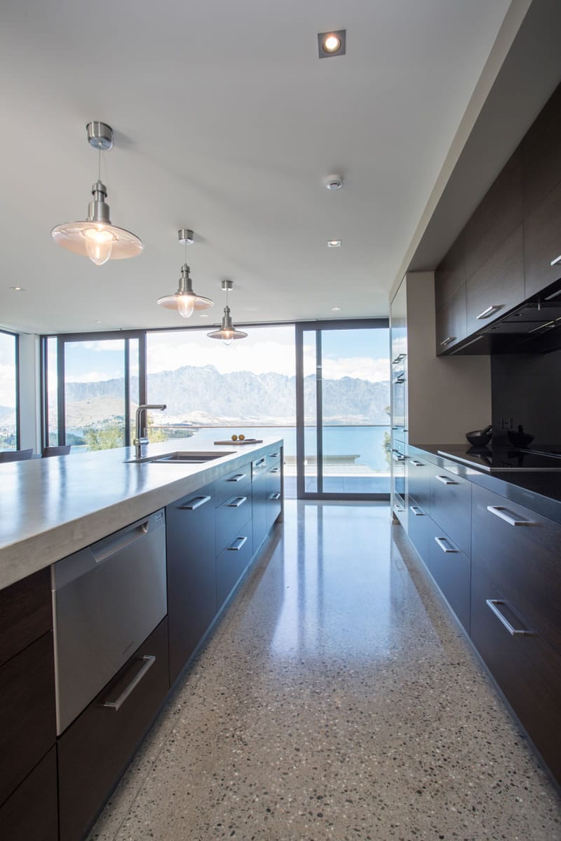 Spacious kitchen with floor to ceiling sliding doors opening to balcony with lake views