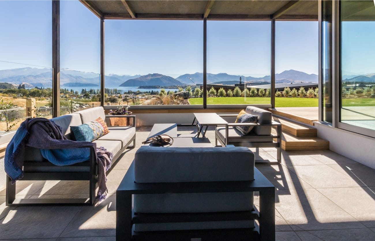 Large living room with floor to ceiling windows overlooking Lake Wanaka